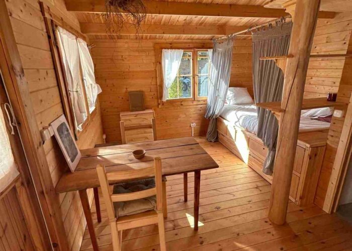 surf bungalow inside room Interior of a wooden surf bungalow with bed and wooden table in Almadena near Lagos